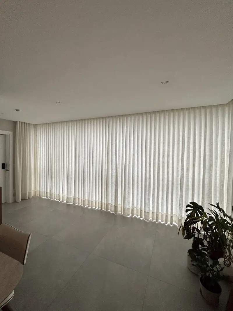 Sala ampla com cortina wave cobrindo a parede inteira