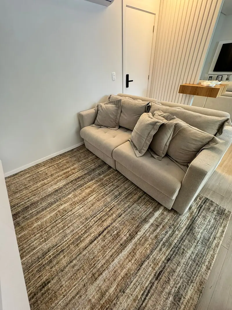 Sofá de linho sobre tapete sob medida em tons de cinza